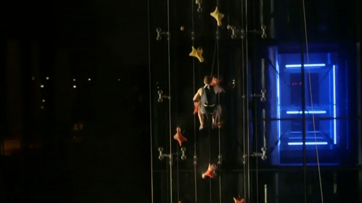 hombre escalando edificio